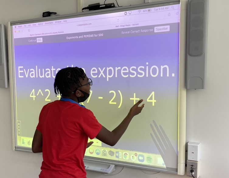 Kid doing math at smartboard 800 X 621